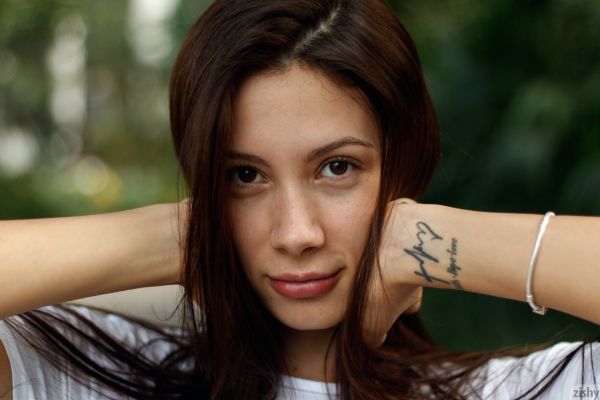 Baggrunde model brunette langt hår Kigger på seeren blomst i