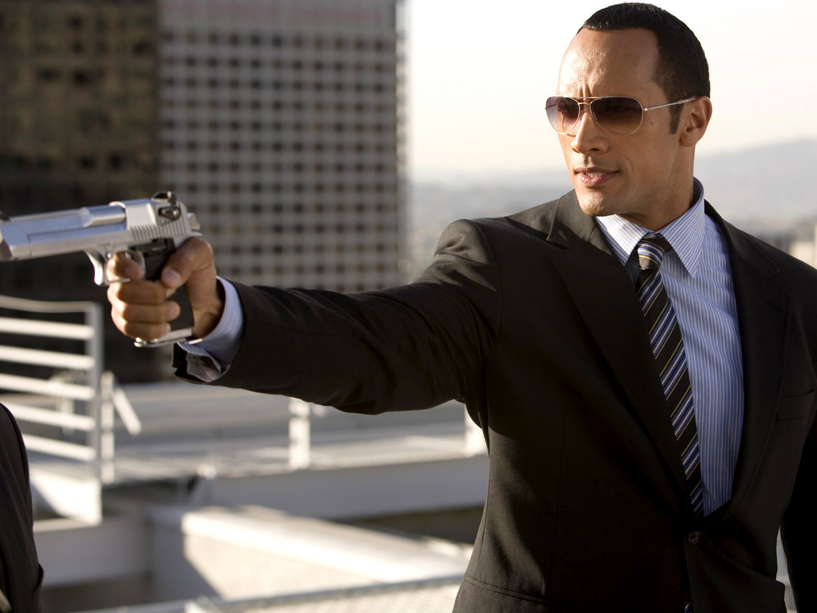 Dwayne Johnson, herec, muž, pistole, ochranné brýle, atletická postava, smoking