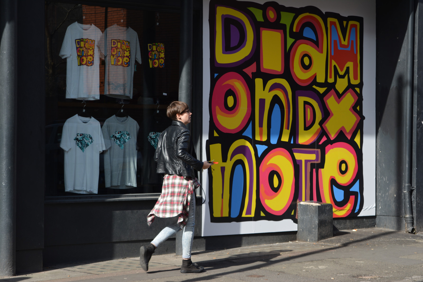 Anglie, Spojené království, Manchester, manchesterstreets, streetphotography, Street View, UrbanScene, streetscene, northernquarter, Oakstreet, Poznámka, Manchestershops, průčelí obchodu, Posterdesign, styledesign, text, plakát, venkovní, Inzeráty, Streetadvertising, Pouliční plakáty, shopposter, chodník, chodník, dívka, ženský, ženy, pěší, zákazník, sportovní oblečení, fashionshop, trička, výloha, skateboardshop, M4