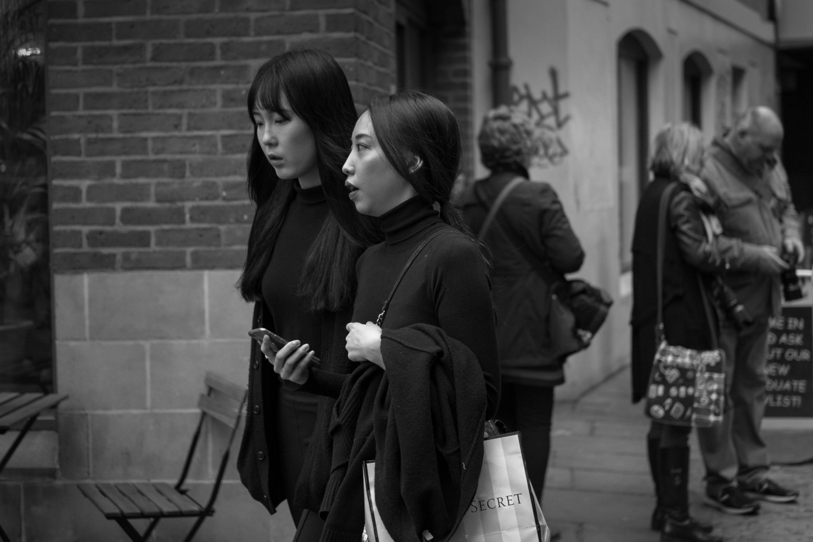 streetphotography, gade, streetportrait, oprigtig, Bristol, fujiholicsphotowalkbristol2016, piger, fotograf, Victoria's hemmelighed, gå, mobiltelefon, Fujifilm, fujifilmxt10, fujinonxf35mmf2rwr, sort hvid, bw, Mono, monokrom